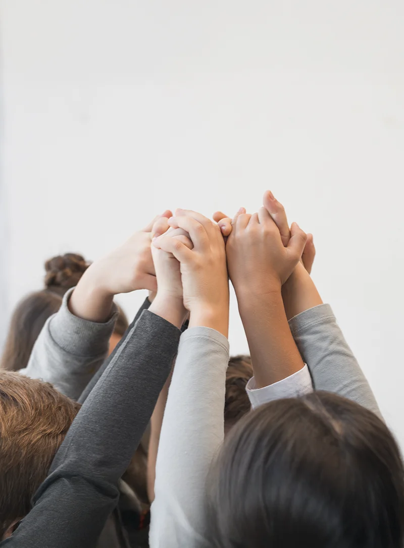 Foto di mani di bambini che si uniscono in alto